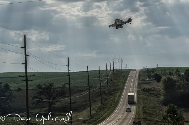 Crop Duster flying over the roadway