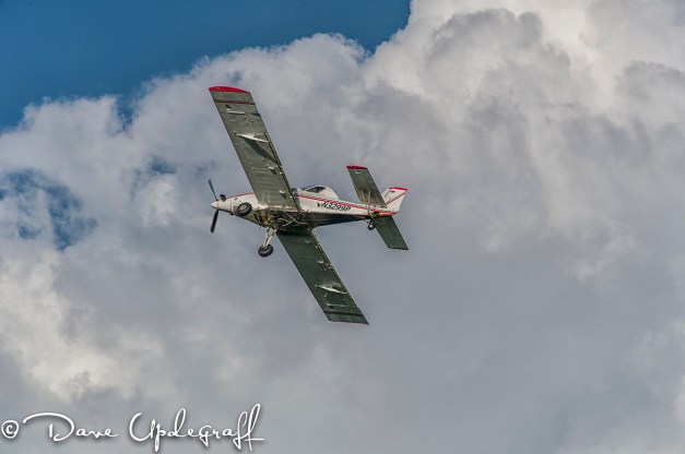 Crop Dusting Plane against a Puffy Cloud